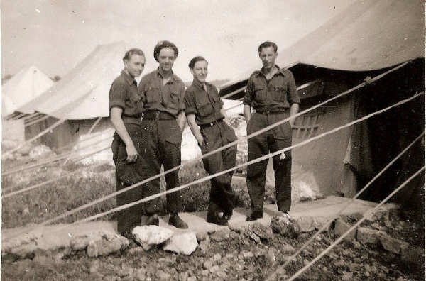 group of soldiers outside row of tents