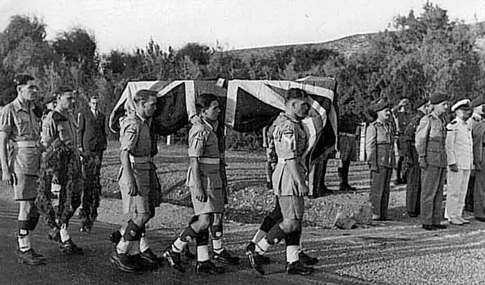 coffin being carried on the shoulders of six soldiers.
