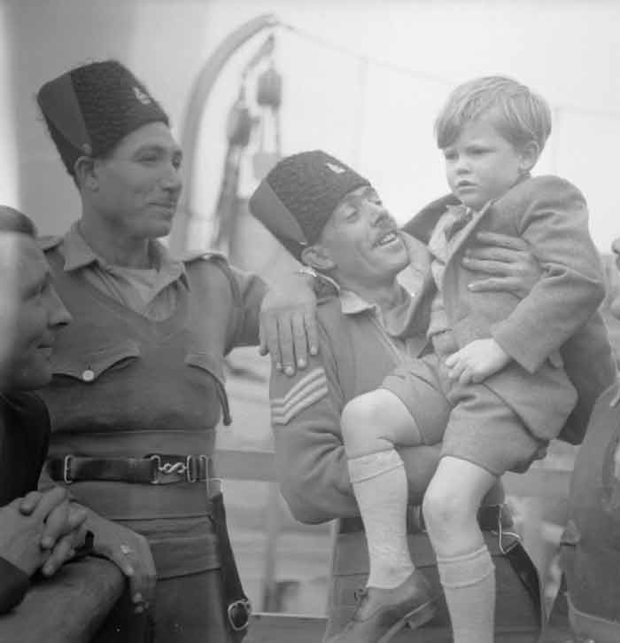 two palestine policemen, one holding small boy who doesn't look too happy