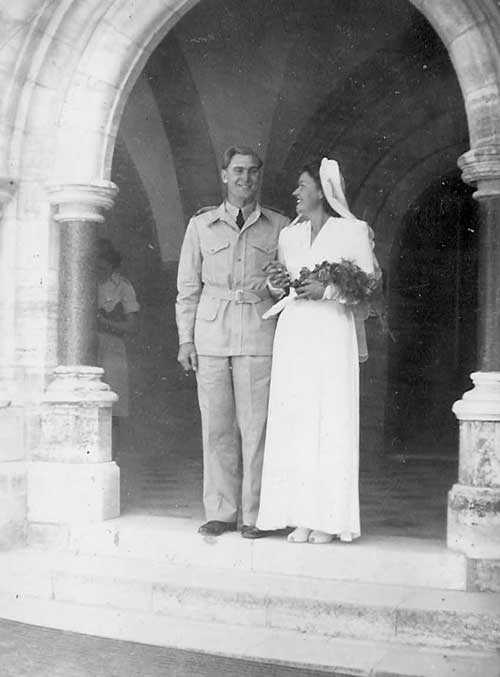 uniformed groom and bride in wedding dress in porch of church